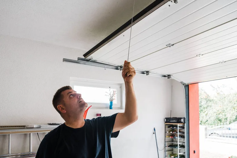 Garage door balance test by American Garage Door Solutions in San Mateo — technician manually testing door weight distribution